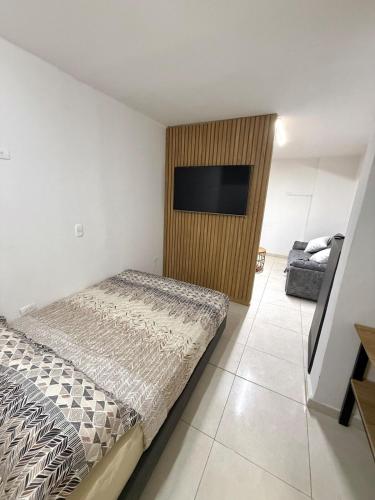 Un dormitorio con una cama y un televisor de pantalla plana. en Apartamento en Cabecera, en Bucaramanga