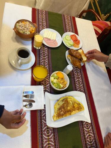 een tafel met een bord met ontbijt erop bij Avraham Hotels in Machu Picchu