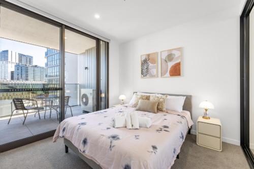 a white bedroom with a bed and a balcony at Chic Woden Apt, Near Hospital, Westfield w Pool in Phillip