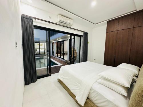 Un dormitorio con una cama grande y una ventana grande. en Athalia Villa Seminyak, en Seminyak