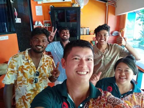 a group of people posing for a picture at Voyagers Hostel in Phi Phi Don