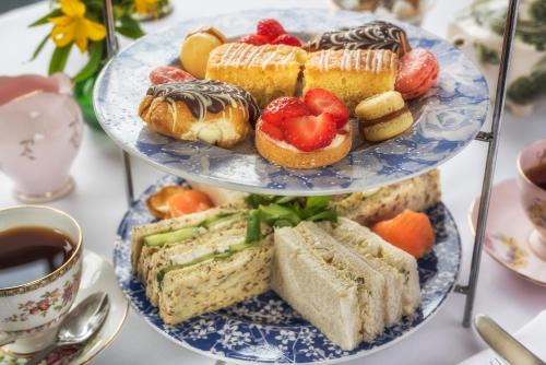 a three tiered plate of food with pastries and desserts at Washingborough Hall Hotel in Lincoln