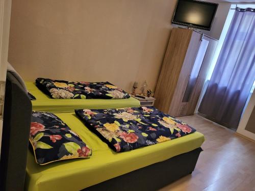 two beds in a room with flowers on them at Unterkunftsresidenz in Erfurt