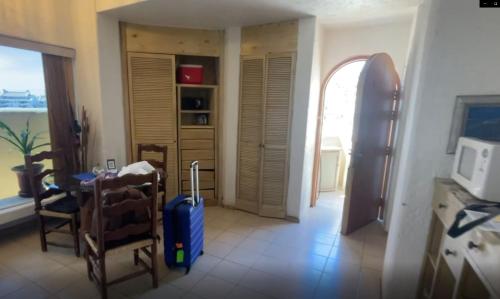 una habitación con una mesa y una maleta en Casa Pura Vida, en Cabo San Lucas