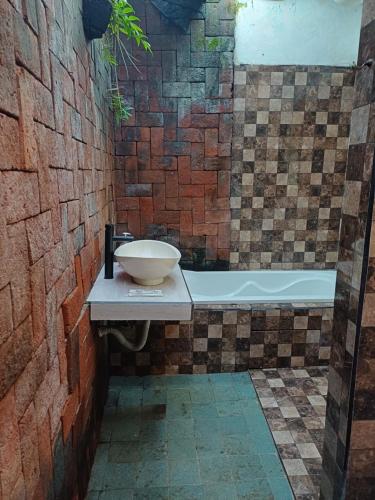 un baño con lavabo y bañera en Green Bowl Bali Guest house, en Ungasan