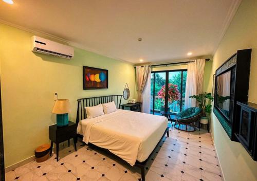 a bedroom with a bed and a television in it at Hometown Signature Retreat Villa Hoi An in An Bang