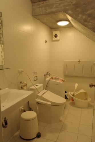 a white bathroom with a toilet and a sink at 無名藝境 in Sanxing