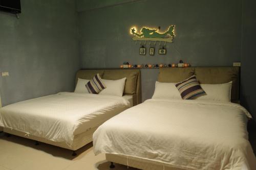 two beds sitting next to each other in a bedroom at 無名藝境 in Sanxing