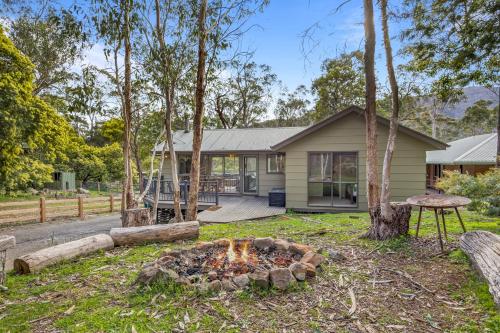 a house with a fire pit in the yard at High Road Haven in Halls Gap
