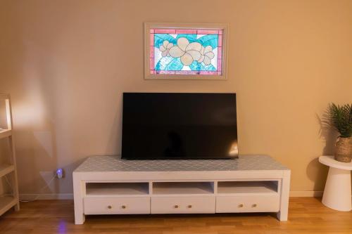 a living room with a tv and a window at Busselton Breeze in Busselton
