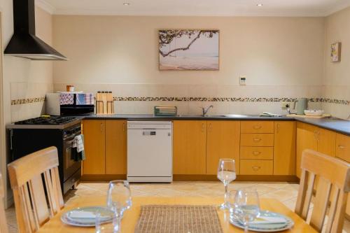 a kitchen with a table and chairs and a kitchen with yellow cabinets at Busselton Breeze in Busselton