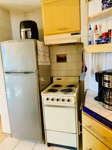 a kitchen with a white refrigerator and a stove at Marina Cabo Plaza "Casa Pura Vida" 108A in Cabo San Lucas