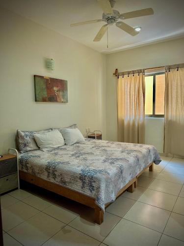 a bedroom with a bed and a ceiling fan at Depa 102A en Huatulco con alberca y terraza 5 min playa in Santa Cruz Huatulco
