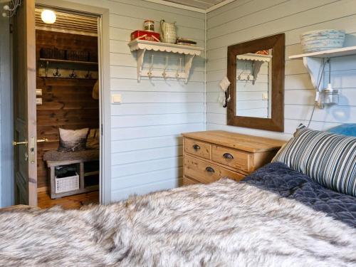 ein Schlafzimmer mit einem Bett, einem Spiegel und einer Kommode in der Unterkunft Cozy Family Cabin At Hamlagrø in Sakhaug