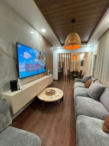 a living room with two couches and a flat screen tv at NEW Villas Milas a few steps from Tela beach in Tela
