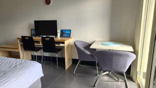 a room with a desk with chairs and a computer at Jopen Motel Unit 6 in Sussex inlet