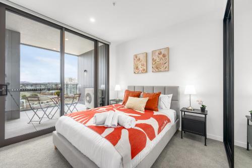 a bedroom with a large bed and a balcony at Cosy Woden Apt Near Canberra Hospital,Transport in Phillip