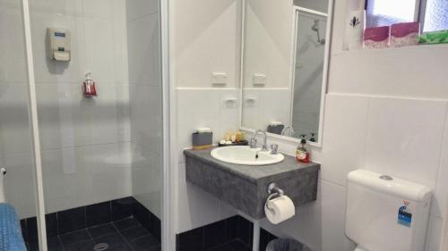 ein weißes Badezimmer mit Waschbecken und Dusche in der Unterkunft Jopen Motel Unit 4 in Sussex inlet