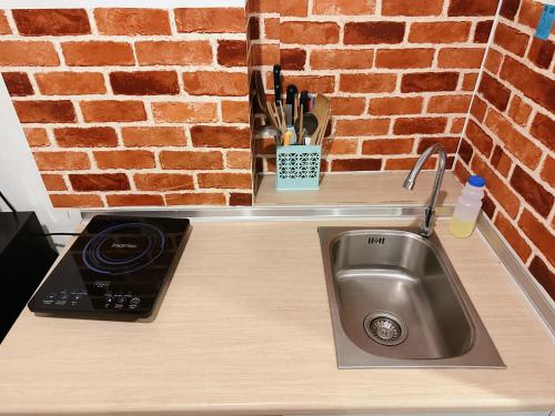 a kitchen counter with a sink and a brick wall at Lumpini Park Beach Jomtien & Seaside Condo in Jomtien Beach