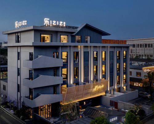 襄陽市にあるLezhizhi Anyu Hotel, Zhuge Liang Plaza Wanda Branchの上に看板がある建物