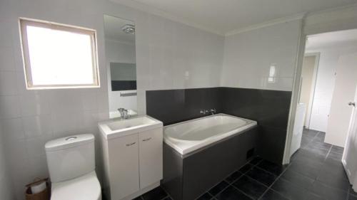 a bathroom with a toilet and a sink and a bath tub at Greentree Sanctuary In South Sussex in Sussex inlet
