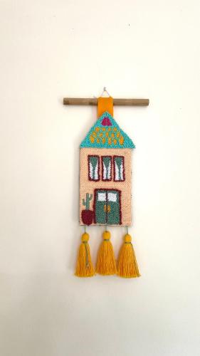 a doll house ornament hanging on a wall at MiTS Youth Hostel in Bandung