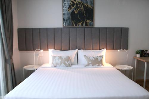 a bedroom with a large bed with white sheets and pillows at Xen Pool Access in Chalong 