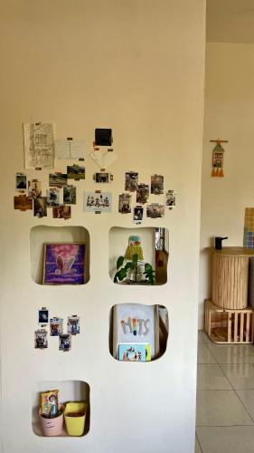 a wall with pictures and photos on a wall at MiTS Youth Hostel in Bandung