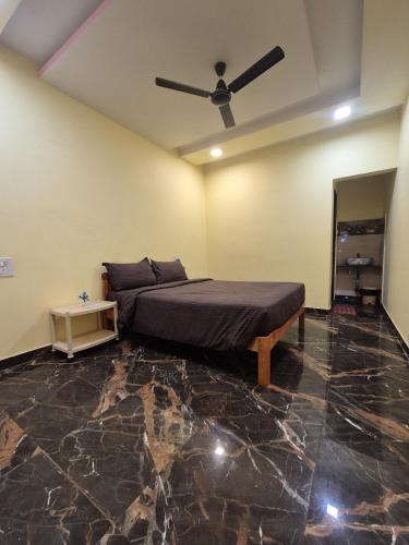 een slaapkamer met een bed en een plafondventilator bij Swayambhu Resort in Malvan