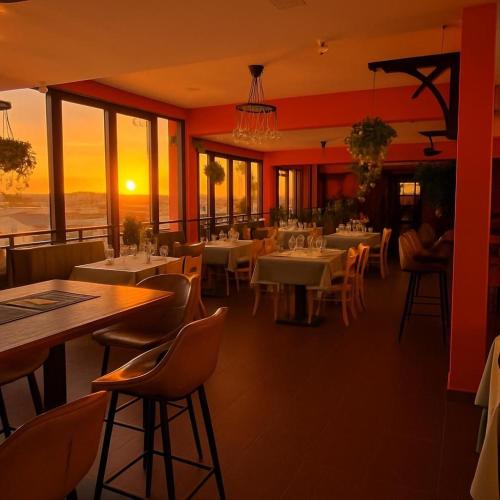 a restaurant with tables and chairs with the sunset in the background at Nico's Hotel 2 in Siem Reap