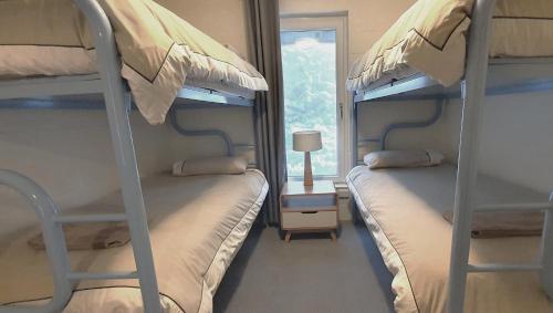 two bunk beds in a room with a window at Alpine View Apartments in Falls Creek