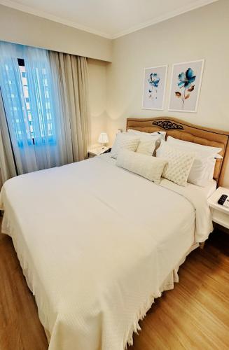 a large white bed in a room with a window at Sao Paulo Ibirapuera Privilege - Suite Deluxe in Sao Paulo