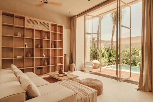 a living room with a couch and a large window at NORI Boutique Villas Uluwatu - Breakfast Available in Uluwatu
