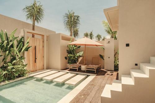 une maison avec une piscine et un parasol dans l'établissement NORI Boutique Villas, Near Nyang Nyang Beach, Uluwatu, à Uluwatu