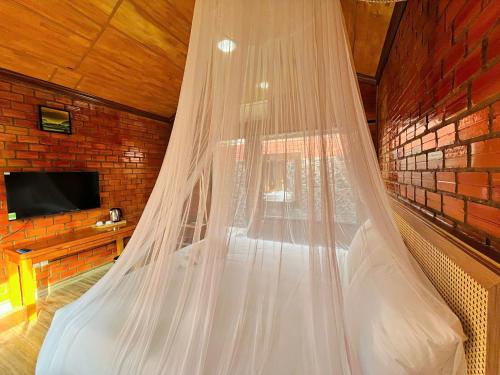 a bed with a mosquito net in a room at Hese Ecolodge Phu Quoc in Phu Quoc