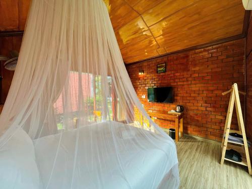 a bedroom with a bed with a mosquito net at Hese Ecolodge Phu Quoc in Phu Quoc