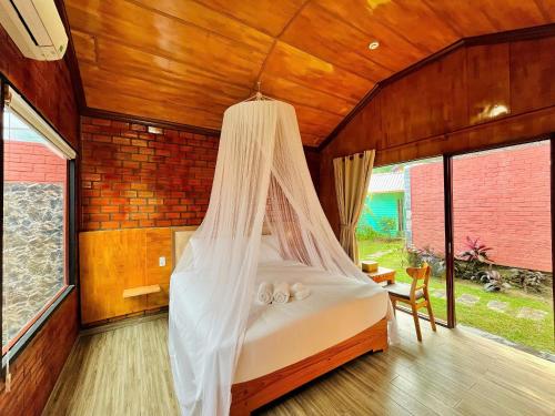 a bedroom with a bed with a mosquito net at Hese Ecolodge Phu Quoc in Phu Quoc