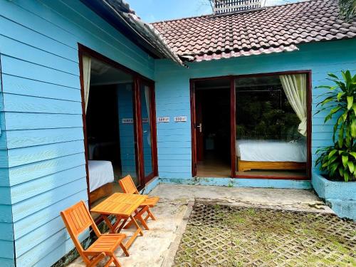 a blue house with two chairs and a table at Hese Ecolodge Phu Quoc in Phu Quoc