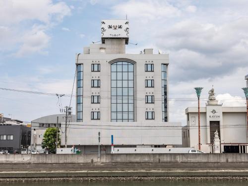 a building with a clock tower on top of it at Tabist HOTEL SWEETWATER in Takamatsu