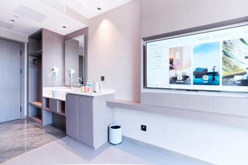uma casa de banho com um grande ecrã na parede em Harbin Airport Lake View Hotel em Harbin