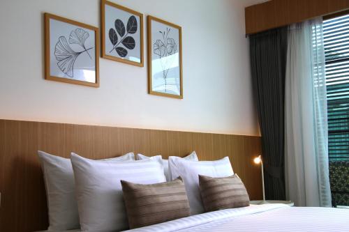 a bedroom with a bed with four pictures on the wall at Xen Pool Access in Chalong 