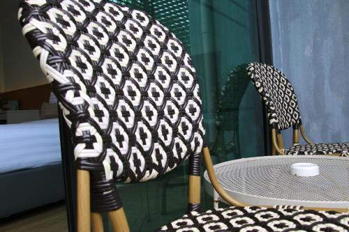 a table and two chairs and a table and a bed at Xen Pool Access in Chalong 