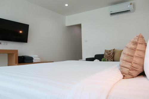 a bedroom with a bed with a television on the wall at Xen Pool Access in Chalong 