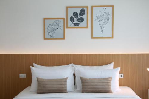a bed with three framed drawings of flowers on it at Xen Pool Access in Chalong 
