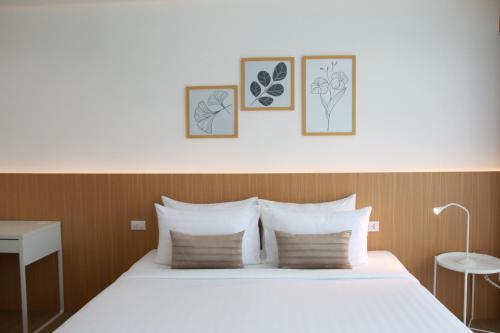 a bedroom with a bed with four pictures on the wall at Xen Pool Access in Chalong 