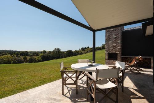 a patio with a table and chairs under a tent at The Brooklet in Byron Bay