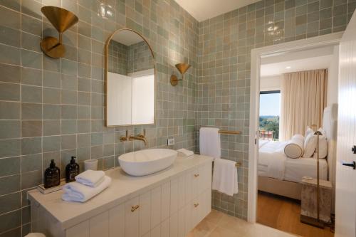 a bathroom with a sink and a mirror and a bed at The Brooklet in Byron Bay