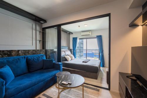 a living room with a blue couch and a bed at NEU 1Bdrnear Airport Pool Gym Mega Bangna in Bang Kew Yai