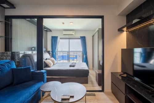 a living room with a blue couch and a tv at NEU 1Bdrnear Airport Pool Gym Mega Bangna in Bang Kew Yai