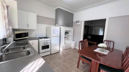 cocina con fregadero y mesa con mesa en Cottage 2 Sussex House Holiday Park, en Sussex Inlet